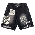 Black washed denim cargo shorts with multiple graphic patches and distressed details, displayed flat against a white background.